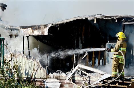  St. Ignatius Volunteer Firefighters work to put out the fire.