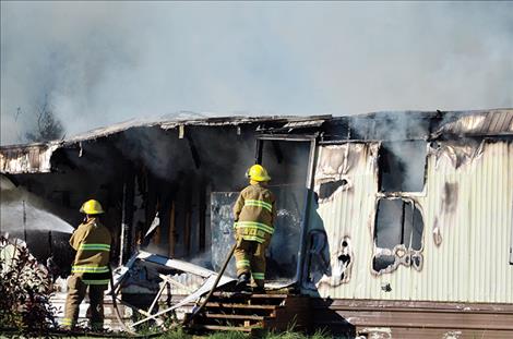  St. Ignatius Volunteer Firefighters work to put out the fire.