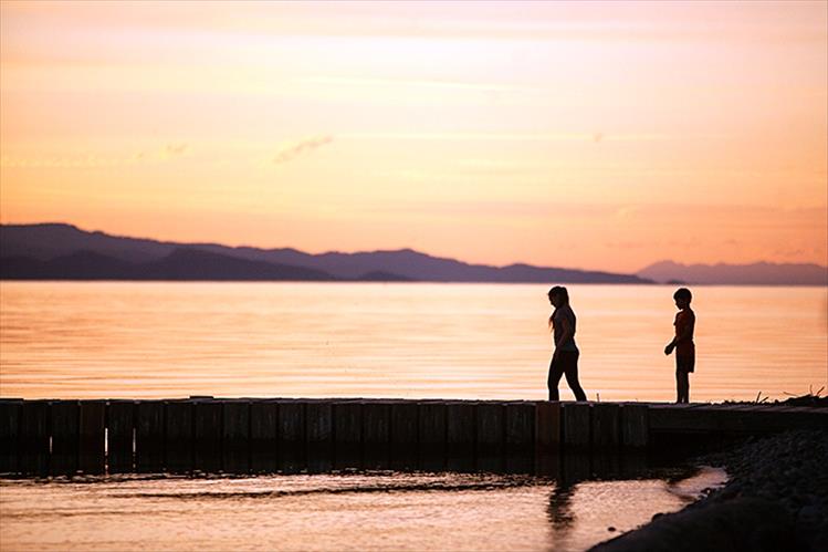 Children enjoy dusk and calm waters at Blue Bay, Flathead Lake