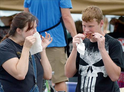 Lisa Stover and her son, Trevor, taste ribs.