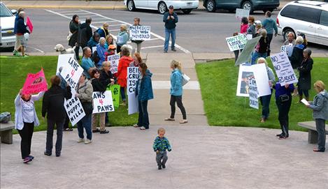 Demonstrators held signs outside the courthouse while couple charged with aggravated animal cruelty appear in Lake County courthouse.