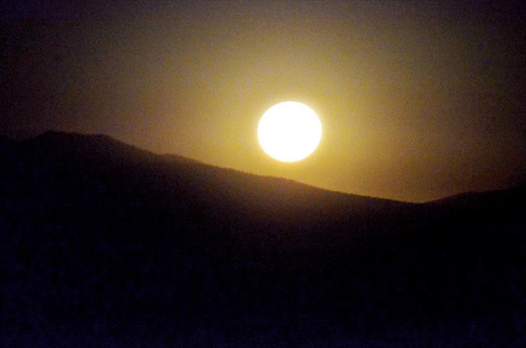 The moon shines its last light just before setting behind the mountains at the Bison Range.