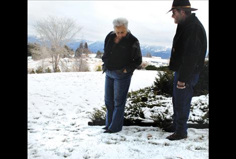 Homeowner Joyce Norman shows Confederated Salish and Kootenai Tribal wildlife biologist George Barce new footprints she discovered in her back yard on Sunday, Dec. 29.