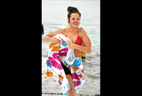 With a smile on her face, a Polar Plunge participant dries off with a beach towel after a dip in the lake.