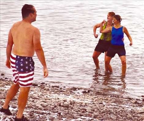 Shauna Rubel and Connie Bull give their families some attitude after plunging into Flathead Lake’s icy waters on New Year’s Day.