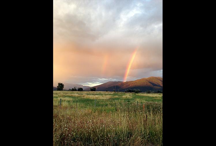 Following a rainstorm in Arlee, a double rainbow colors the sky.