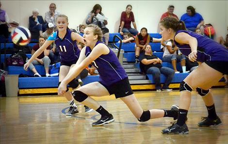 Charlo junior Vaness Kent reacts to her dig, center, as Kaitlin Cox, left, prepares for her move during a recent game in Drummond. Cheyenne Nagy goes up for the kill in Drummond.