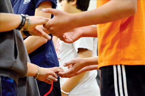 Dancers hold hands for a few moments before moving down the line.