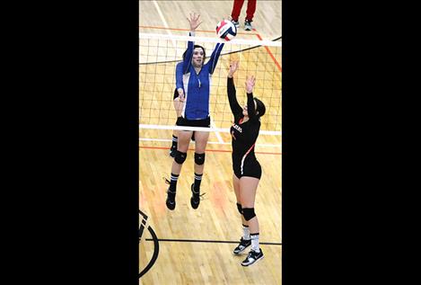 Mission’s Afton Brander goes up for a block against Ronan’s Shaina Snyder during a Sept. 22 game in Ronan.