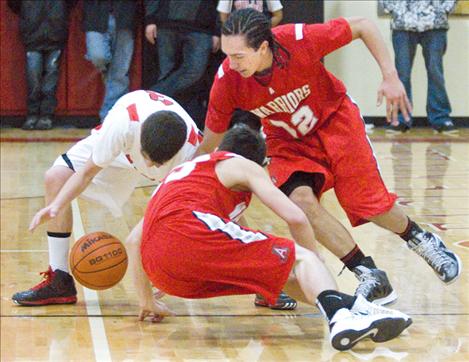 Warrior senior and point guard Zach Camel scrambles for the ball along with teammate Dominic Burland and Two Eagle’s Cole Noble. Camel, whose strategy as a point guard is “pass first,” has turned in triple-doubles in Arlee’s last three games, starting with Mission Jan. 5. In Saturday’s contest with Two Eagle River, Camel tallied 19 points,14 assists and 10 rebounds. 