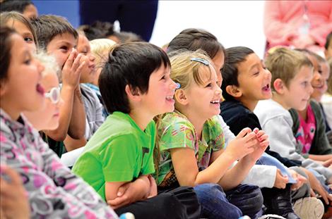Kids laugh as the author reads them a funny story.