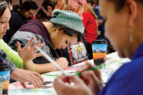 People paint over more than 50 two-inch squares during a community art project.