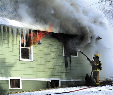 Flames shoot from a window of Robert and Nancy Rider's North Crow home Monday. The house was destroyed in a blaze that took firefighters nearly six hours to extinguish.