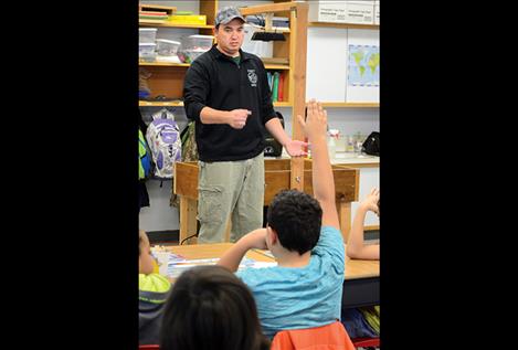 Chauncey Means asks students some science-related questions before demonstrating the Augmented Reality Sandbox.