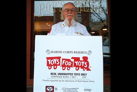 Franz McLaren, coordinator for the local Toys for Tots project, is pictured with a collection box outside Pop’s Grill in Polson.