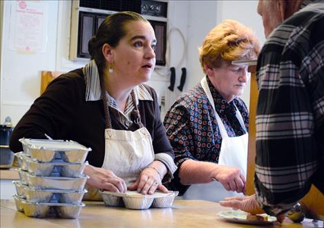 Desiree Alexander, left, and Kaye Stam serve meals and package food to go in Polson.