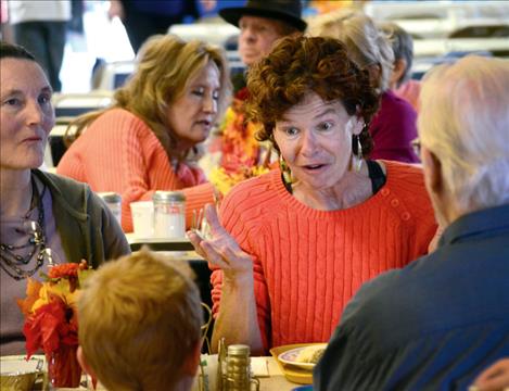 Kim Schmidt visits with new friends at Polson’s Community Thanksgiving dinner.