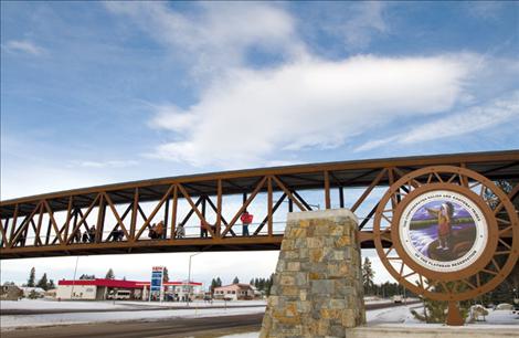 Participants at an Idle No More rally held Friday in Pablo file across the pedestrian bridge in Pablo, displaying signs and posters for traffic below.