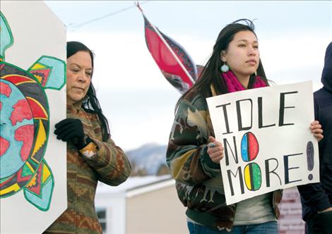 Polson High School English teacher Linda Pete and PHS student Chrystal Woods display colorful posters during an Idle No More rally Friday in Pablo. The purpose of the rally and similar ones nationwide, is to draw attention to Native American land rights issues. Local demonstrators marched from Confederated Salish and Kootenai Tribal headquarters over the pedestrian bridge to Salish Kootenai College, ending with drumming, singing and a round dance in the Joe McDonald Health and Fitness Center parking lot.
