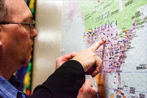 Ian Donovan helps Lenore Mihara place pins on a map to show where her family is from.