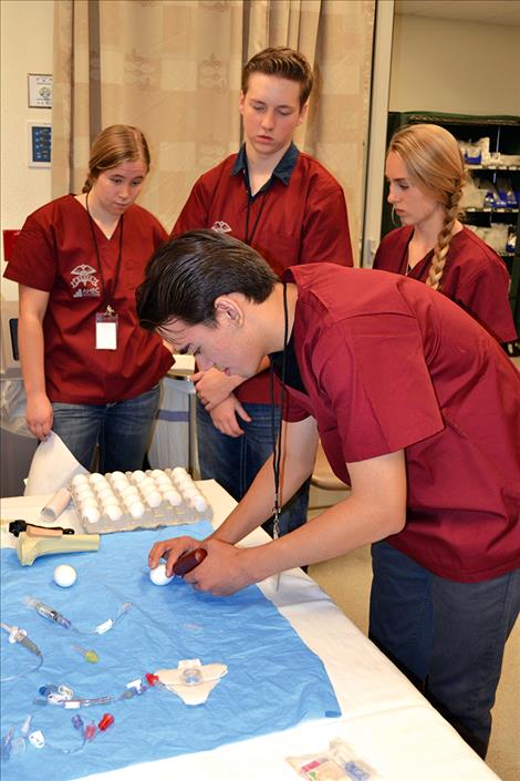 Students practice medical skills using eggs.