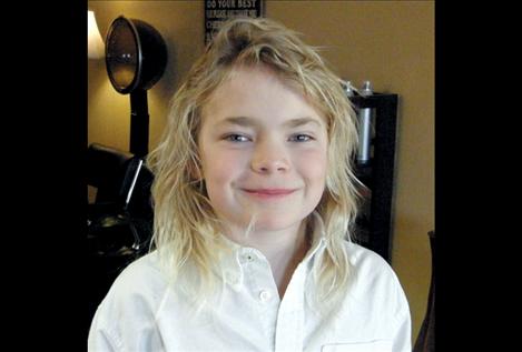 Polson third-grader Ethan McCauley  displays  his blond locks before cutting his hair to donate to Locks of Love. 