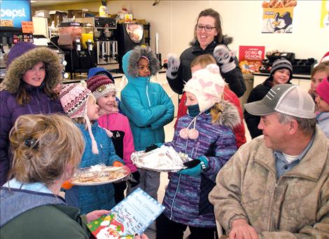 Students present cookies to Sarah and Tim Schauss, owners of Pablo Foods, while teacher Nicky Buck celebrates.