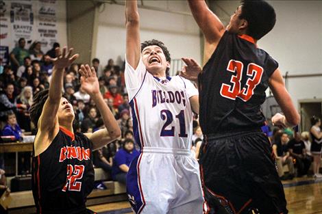 Bulldogs’ Wacey McClure battles Chief defenders under the basket.