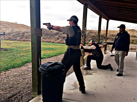 Sergeant Dan McClure checks firearms proficiency as Chief Pablo Espinoza kneels and fires and Investigator Brandon Couture stands and fires.