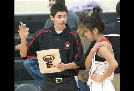 Lady Eagles assistant coach Artie Mendoza talks strategy with Ruby Saluskin before Friday night’s game.Mendoza played for the Two Eagle River boys’ basketball team last year.