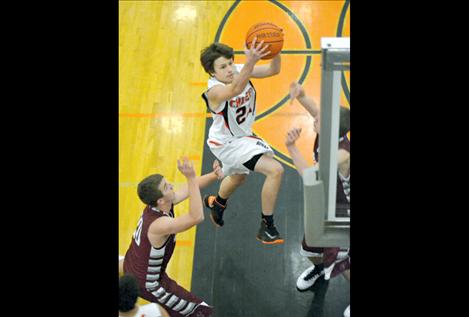 Sophomore Colton McCrea soars over two Hamilton players Friday night on his way to the bucket.
