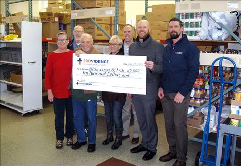 The Polson Loaves and Fish food pantry accepts a donation of $10,000. Pictured with a check are, from left, Mary Martin, food pantry president; Bryan River, food bank manager; Merle Parise, food pantry volunteer; Rosemary Smith, food bank volunteer; Greg Hertz, owner of Super 1 Foods; Landon Godfrey, Providence St. Joseph Medical Center Director of Hospital Operations; and Ira Brown, Providence St. Joseph Medical Center Rehab Services Manager.