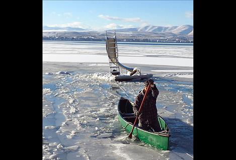 Justin Fisher breaks through the ice after attaching a rope to a floating dock so it could be pulled to shore.