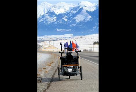 Lewis’ stroller, containing all his equipment and displaying a flag from every branch of service, rolls unattended down Ravalli hill toward St. Ignatius. 