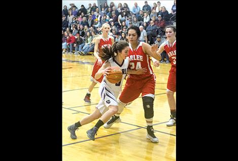 Charlo’s Cheyenne Nagy drives toward the basket as Scarlets’ Alyssia Vanderburg defends the hoop.