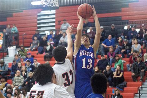 Bulldogs’ Elijah Cahoon takes the ball to the hoop over Ronan defenders.