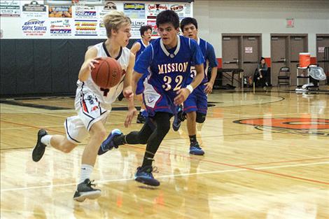 Chiefs’ Jackson Duffey brings the ball down court under heavy defense from Bulldogs’ Isaac Alexander.