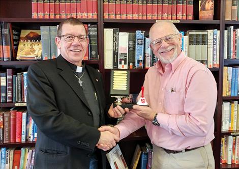 Russ Barber, right, pastor of Polson Community Church, hands off the bell ringing trophy to Rev. Steven Yurosko of St. Andrew’s Episcopal Church.