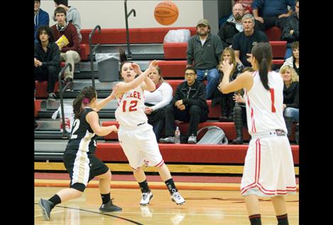 Arlee Scarlet Skyla Perry passes the ball to Whitney Malatare during a game earlier this season. The Scarlets lead District 14-C with an undefeated record.