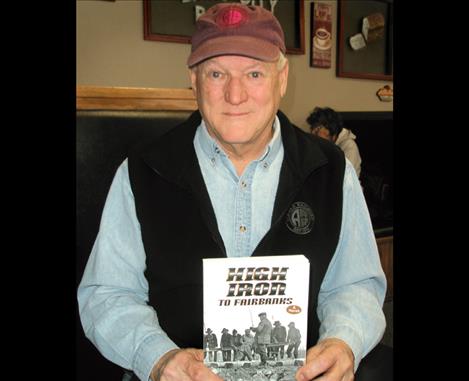 Evan McKinney holds his new book, High Iron to Fairbanks, a fictional history of the making of the Alaska Railroad.