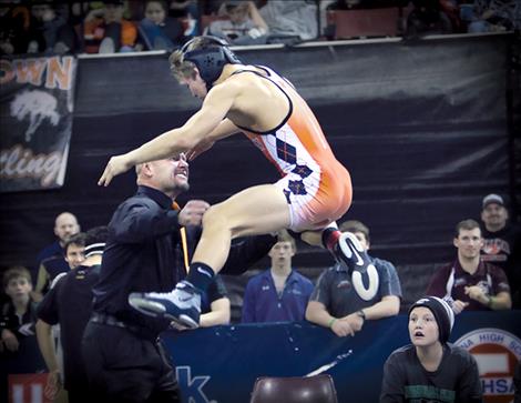 Ronan Chief Noah Cheff leaps into father and coach Hap Cheff’s arms after winning the state championship by pinning his opponent in 14 seconds.