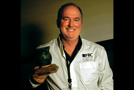 FLIC co-chair Daniel Smith displays a FLIC award made by Polson artist Matt Holmes.