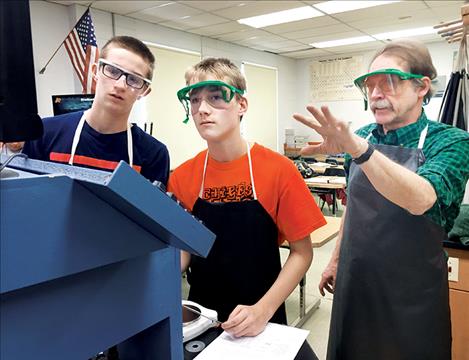 Science teacher Phil Engeldrum helps Ronan High School freshmen Evan Denny and Blaise Wikstrom test salinity values of different types of water.