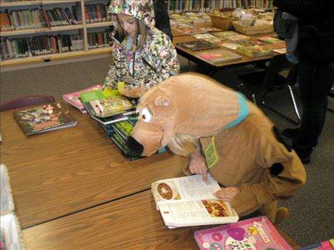 Second-grader Finn Goddard (Scooby Doo) and first-grader Analeigh Bryant look for books at Linderman Library. 