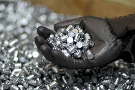 An employee of RimRock Bullets in Ronan holds a handful of newly-cast bullets.The bullet manufacturer, which does not make ammunition, has seen a jump in sales over the past several weeks. 