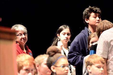 Guinevere Contreras, center, waits behind Davien Adams to spell a word at the microphone, both students took third place, and Contreras won the Alternate title.