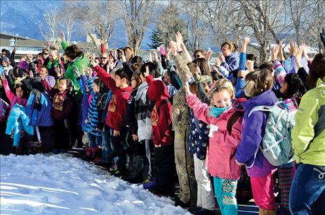 Students raise hands in agreement after being asked if they want to see the principal on the roof.