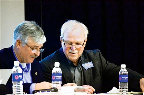 Lake County delegates to the Montana Legislature Dan Salomon, republican, and John Fleming, democrat, look up information together as they sit on the panel answering questions from the public.