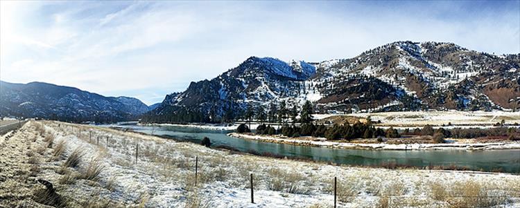 The Flathead river appears emerald green as it winds along Hwy. 200 on a sunny, winter day.