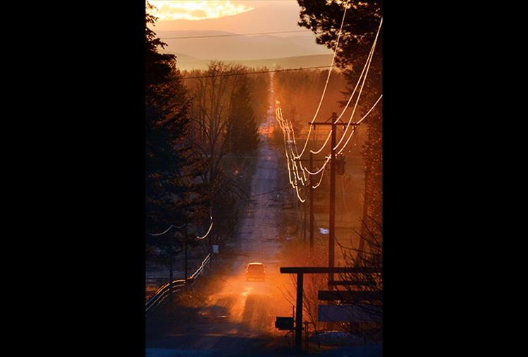 The setting sun illuminates electrical lines along Courville Trail east of Pablo Thursday evening.